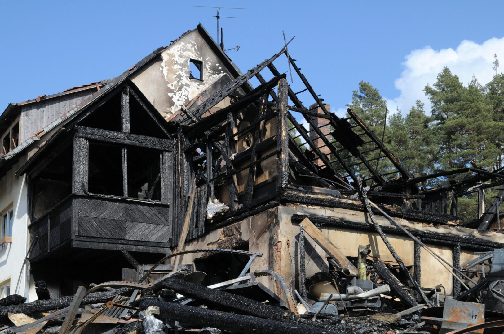 Burned-out house with charred wooden structure.