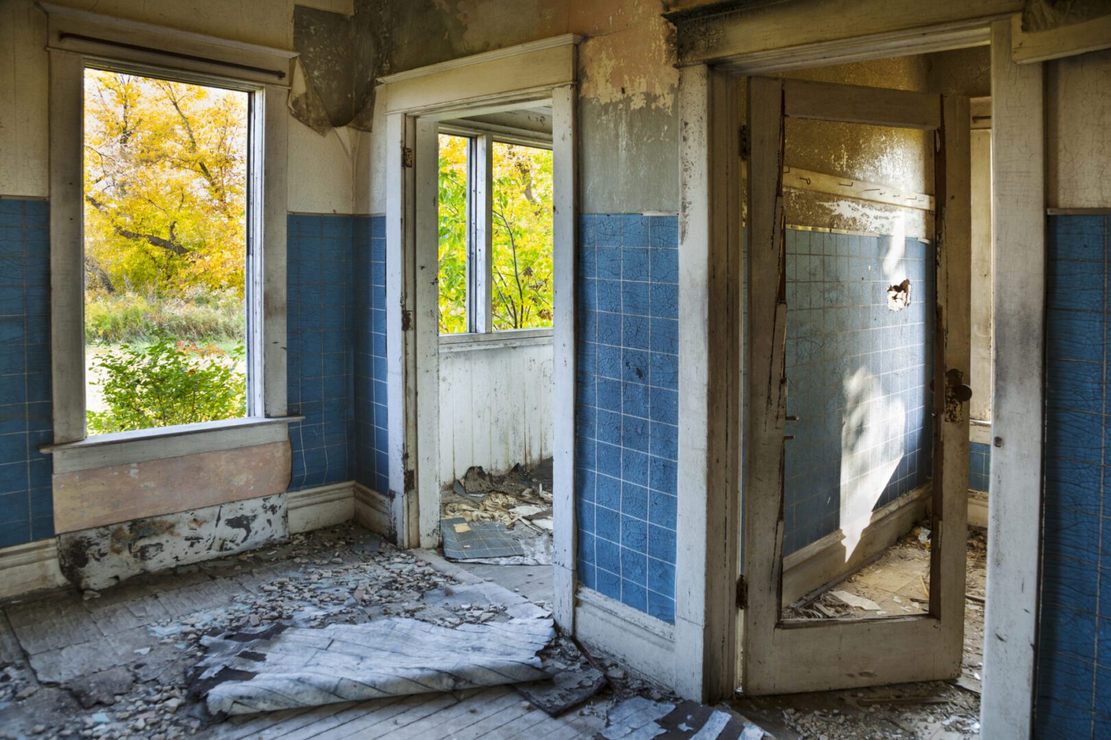 Abandoned room with peeling paint and doorway.